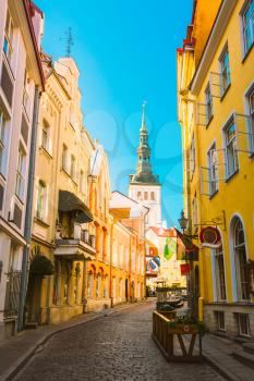 Tallinn, Estonia. View Of Narrow Street In Sunny Summer Day Under Blue Sky. Old Architecture And Different Cafes And Restaurants In Popular Touristic Route.