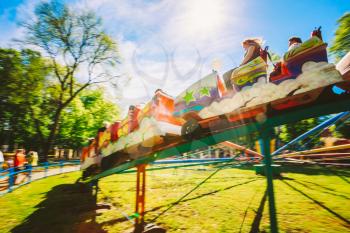 People Having Fun On Rollercoaster In The Park. Photo With Zoom Blur For Motion Effect