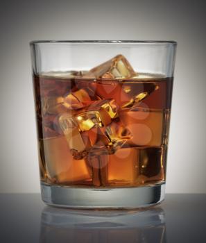 Glass of whiskey and ice over dark background