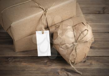 Heart and box wrapped in brown kraft paper on wooden table closep