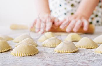 hand with rolling pin and flour, making dumpling
