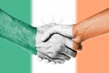 Man and woman shaking hands, wrapped in flag pattern, Ireland