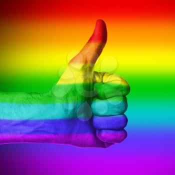 Image of a mans hand showing thumb up in isolation, rainbow flag pattern