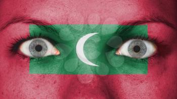 Close up of eyes. Painted face with flag of Maldives