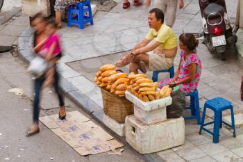 HANOI, VIETNAM, 8 AUGUST 2012; Vietnamese street vendor selling France loaf at street. Estimate 10.6% of Vietnam's population is below the poverty line. HANOI, VIETNAM, 8 AUGUST 2012