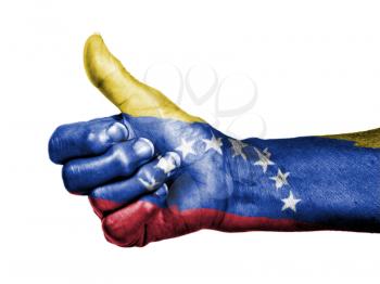 Old woman with arthritis giving the thumbs up sign, wrapped in flag pattern, Venezuela