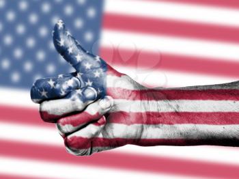 US flag on thumbs up hand isolated on a flag background