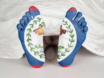 Feet with flag, sleeping or death concept, flag of Belize