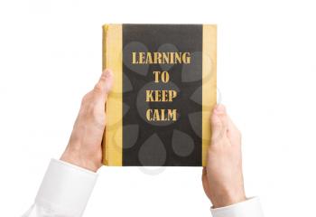 Businessman holding an old book, learning to keep calm