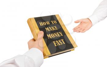 Businessman giving an used book to another businessman, how to make money fast