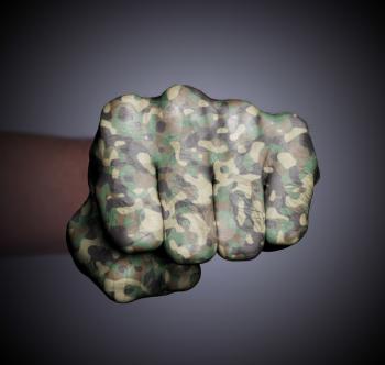 Front view of punching fist on gray background, camouflage
