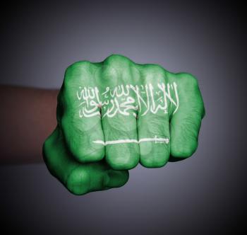 Front view of punching fist on gray background, flag of Saudi Arabia