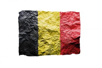 Close up of a curled paper on white background, print of the flag of Belgium