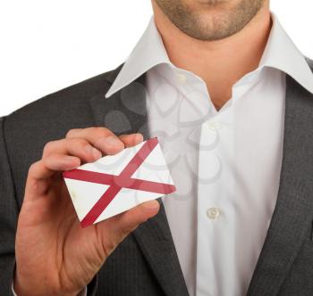 Businessman is holding a business card, flag of Alabama