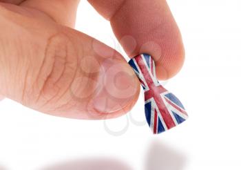 Hand holding wooden pawn with a flag painting, selective focus, United Kingdom