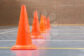 Interior of a gym at school, red cones on a row
