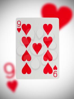 Playing card with a blurry background, nine of hearts