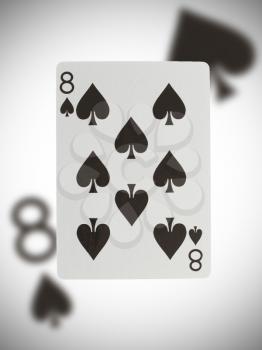 Playing card with a blurry background, eight of spades