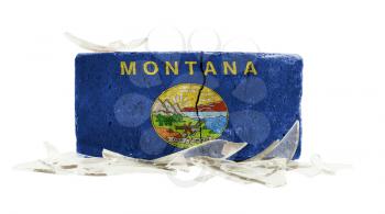 Brick with broken glass, violence concept, flag of Montana
