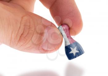 Hand holding wooden pawn with a flag painting, selective focus, Texas