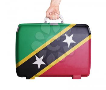 Used plastic suitcase with stains and scratches, printed with flag, Saint Kitts and Nevis