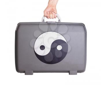 Used plastic suitcase with stains and scratches, printed with sign, Yin Yang