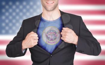 Businessman opening suit to reveal shirt with state flag (USA), Minnesota