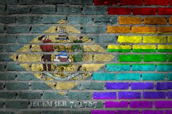 Dark brick wall texture - coutry flag and rainbow flag painted on wall - Delaware