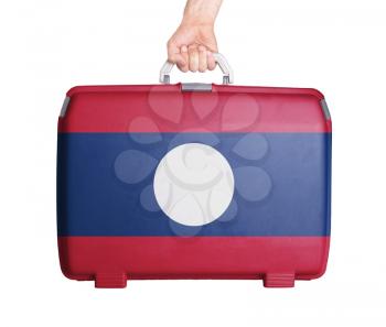 Used plastic suitcase with stains and scratches, printed with flag, Laos