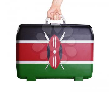 Used plastic suitcase with stains and scratches, printed with flag, Kenya