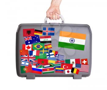 Used plastic suitcase with lots of small stickers, large sticker of India