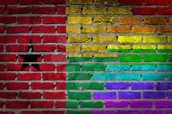 Dark brick wall texture - coutry flag and rainbow flag painted on wall - Guinea Bissau