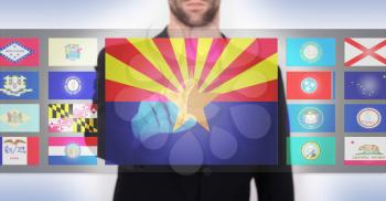 Hand pushing on a touch screen interface, choosing a state, Arizona