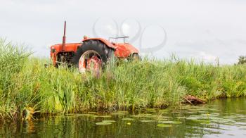 Farmers pumping water with old tractor, the Netherlands