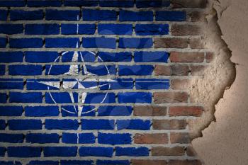 Dark brick wall texture with plaster - flag painted on wall - NATO