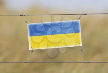 Border fence - Old plastic sign with a flag - Ukraine