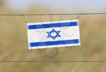 Border fence - Old plastic sign with a flag - Israel