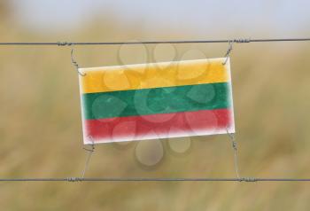 Border fence - Old plastic sign with a flag - Lithuania