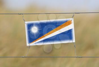 Border fence - Old plastic sign with a flag - Marshall Islands