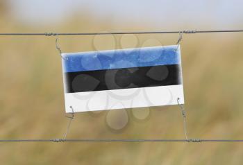 Border fence - Old plastic sign with a flag - Estonia