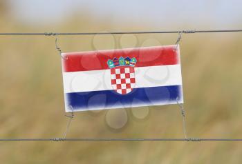 Border fence - Old plastic sign with a flag - Croatia