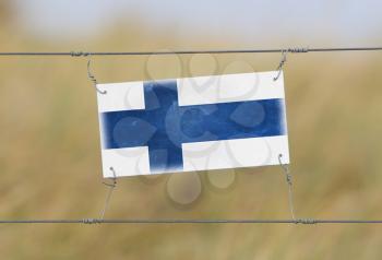 Border fence - Old plastic sign with a flag - Finland