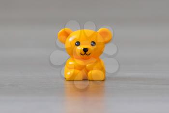 Small yellow bear on a wooden floor