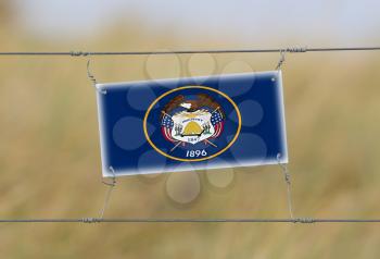 Border fence - Old plastic sign with a flag - Utah