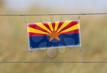 Border fence - Old plastic sign with a flag - Arizona