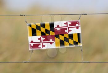 Border fence - Old plastic sign with a flag - Maryland