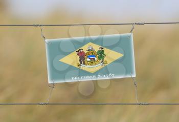 Border fence - Old plastic sign with a flag - Delaware