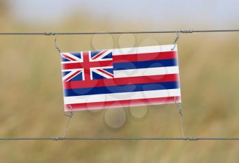 Border fence - Old plastic sign with a flag - Hawaii