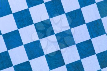 Very old wooden chess board, isolated close-up, blue