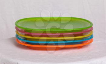 Colorful plastic plates closeup isolated on white background